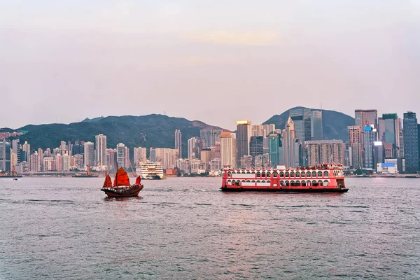 Junk boot in Victoria Harbor van Hong Kong bij zonsondergang — Stockfoto