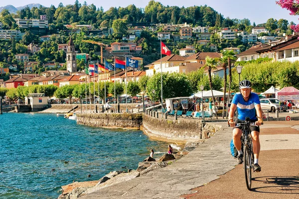 Hombre montar en bicicleta en el paseo marítimo de Ascona en Ticino Suiza — Foto de Stock