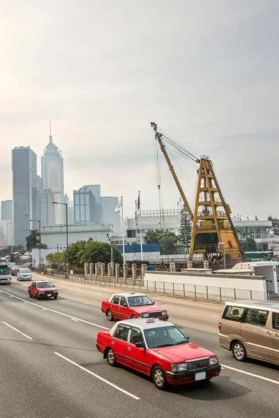 Gratte-ciels modernes le long de la route et taxi sur Hong Kong — Photo