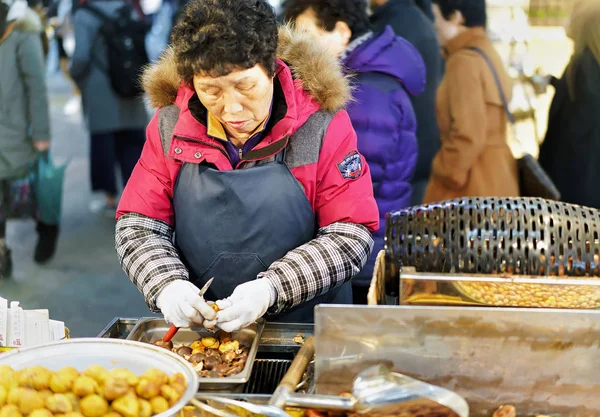 Mujer vendiendo comida en el mercado callejero de Myeongdong en Seúl — Foto de Stock