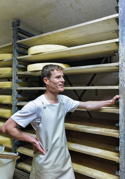 Dělník a zrání sýr v zrání sklep Franche Comte mléčné — Stock fotografie