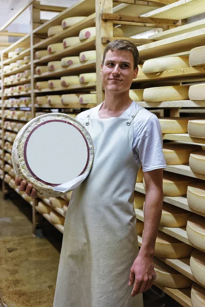 Lavoratore con una ruota di formaggio presso il caseificio Franche Comte — Foto Stock