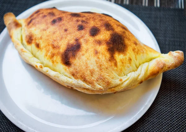 Pizza Calzone på vit platta — Stockfoto