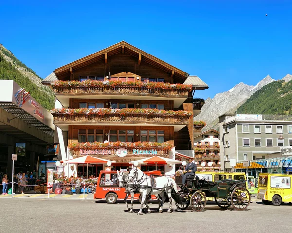 Häst fordon och turister på City center Zermatt — Stockfoto