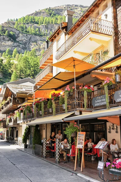 Turisté v restauraci s terasou v centru Zermattu — Stock fotografie