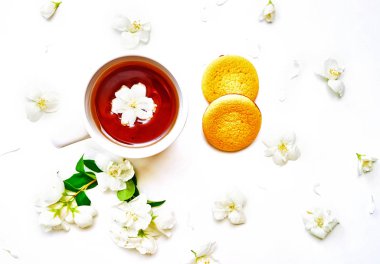 Yasemin çiçekleri ve beyaz arka plan üzerinde çay bardağı