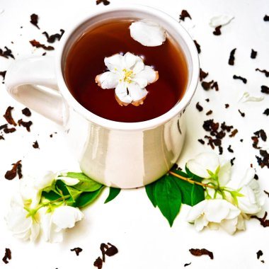 Çay bardağı kurutulmuş Yasemin ve taze kokulu Yasemin çiçekleri ile