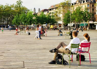 Zürih'te Sechselautenplatz sandalye üzerinde oturan genç insanlar