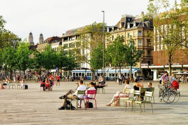 Zürih'te Sechselautenplatz sandalye üzerinde oturan insanlar