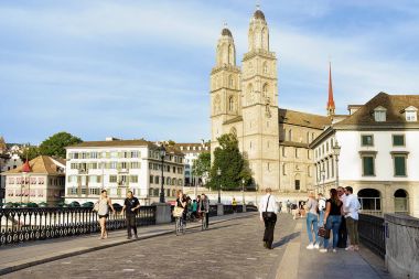 İnsanlar Munsterbrucke köprü ve kilise Grossmunster Zürih