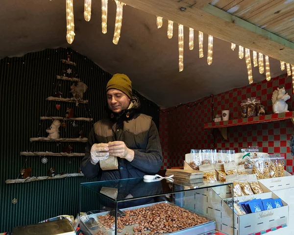 Seller at Counter with nuts at Xmas market in Vilnius — Stock Photo, Image