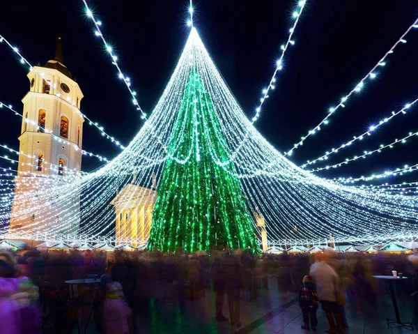 Gente en el mercado de Navidad de Vilnius y árbol de Navidad por la noche —  Fotos de Stock