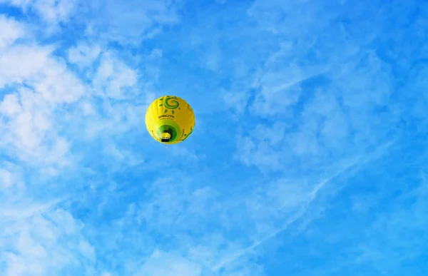 Färgglada gul luftballong flyger i himlen — Stockfoto