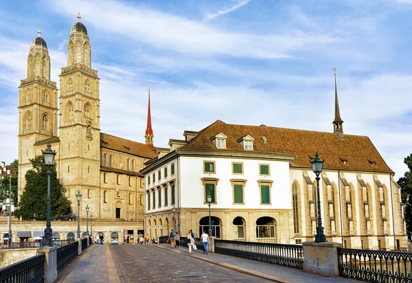 Emberek a Munsterbrucke híd és a templom Grossmünster Zürichben — Stock Fotó