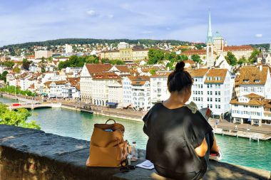 Zürih bakarak ve Lindenhof Hill'de oturan kız yaptırın
