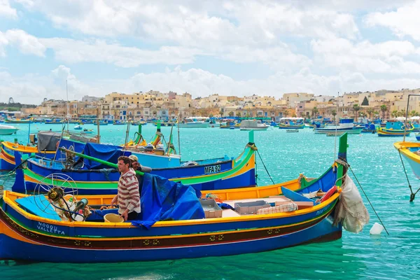 Рыбаки на красочной лодке Luzzu в гавани Марсашлокк на Мальте — стоковое фото