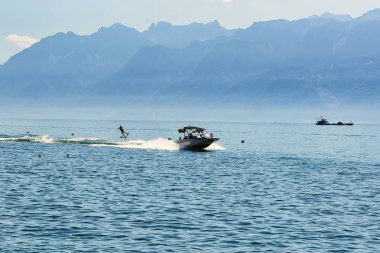Motorlu tekne ve adam wakeboarding Lozan Cenevre Gölü üzerinde