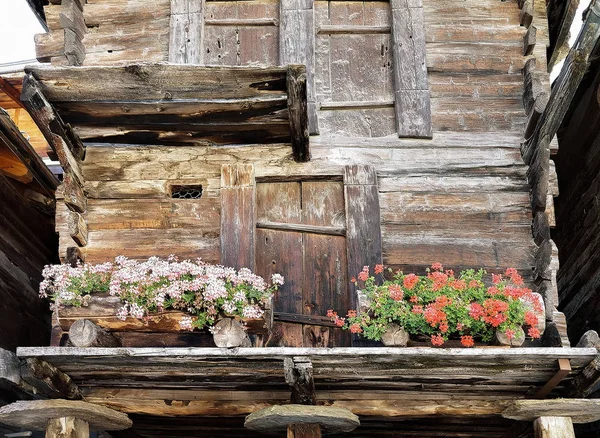 Balkon z kwiatami w domku w miejscowości Zermatt, w Szwajcarii — Zdjęcie stockowe