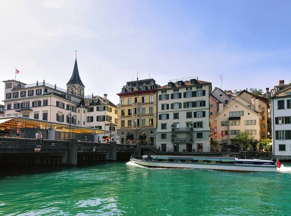 Crucero fluvial en el muelle de Limmat Iglesia de San Pedro en Zurich — Foto de Stock