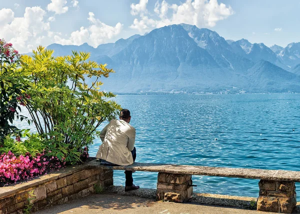 Az ember ül a padon a töltésen, a Genfi-tó Montreux — Stock Fotó