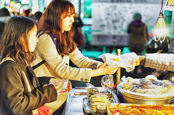 Meisjes kopen van straatvoedsel in Myeongdong straat markt Seoul Azië — Stockfoto