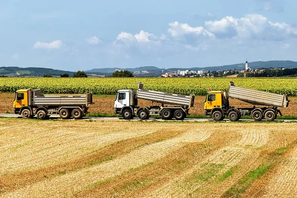 Vrachtwagens na het doen van seizoensgebonden werk in de landbouw in veld — Stockfoto