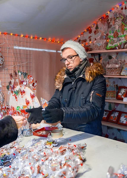 Prodávající u stánku s bonbóny barevné perník na Vilnius vánoční trh — Stock fotografie