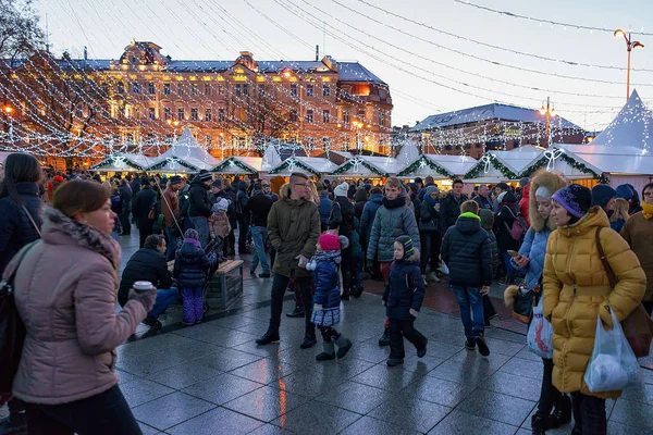 Gente divirtiéndose en el mostrador en el mercado de Navidad en Vilna —  Fotos de Stock