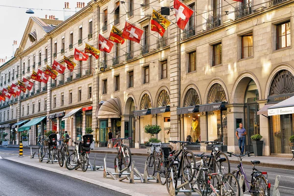 Велосипеды на улице Rue Corraterie с швейцарскими флагами Женевы — стоковое фото