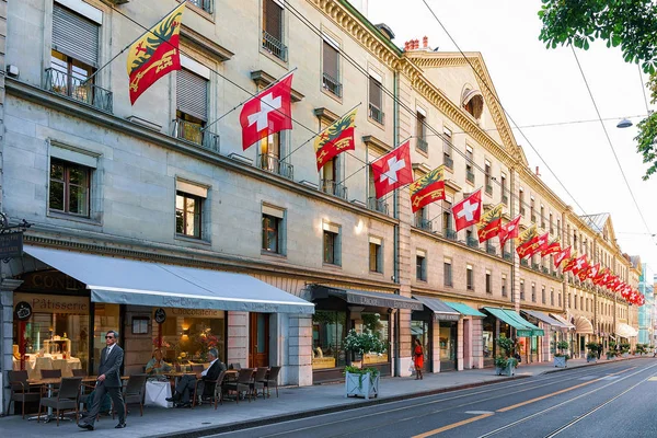 Улица Rue de la Corraterie с флагами Швейцарии в Женеве — стоковое фото