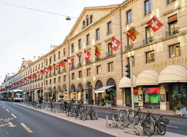 A vonat és a kerékpárok a Corraterie Street svájci zászlók Genfben — Stock Fotó