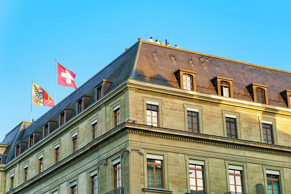 Швейцарские флаги на крыше здания в Женеве
