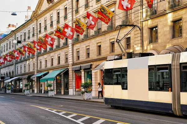 Трамвай на улице Rue Corraterie Street со швейцарскими флагами в Женеве — стоковое фото