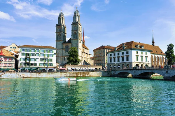 Barco a motor no rio Limmat e Igreja Grossmunster em Zurique — Fotografia de Stock