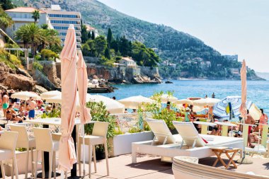 Sığınak ve Adriyatik Denizi Dubrovnik, plajda şezlonglar