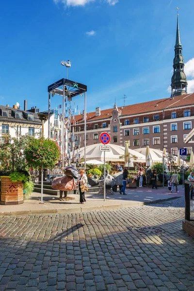 Piazza piena di gente e guglia Chiesa di San Pietro Riga — Foto Stock