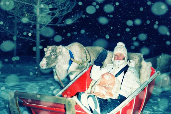 Vrouw op rendieren slee bij nacht safari in Lapland Finland — Stockfoto