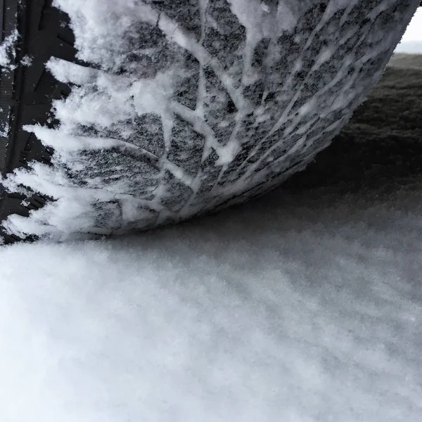 路上的雪覆盖着的汽车轮胎的特写 — 图库照片