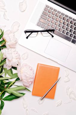 İşyeri dizüstü gözlük defter kalem ve peonies ile