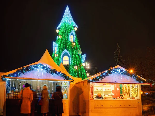 La gente en el mercado de Navidad en la noche Vilnius —  Fotos de Stock