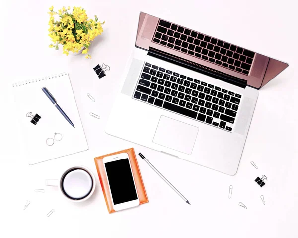 Espacio de trabajo portátil teclado café teléfono móvil gafas y flores — Foto de Stock