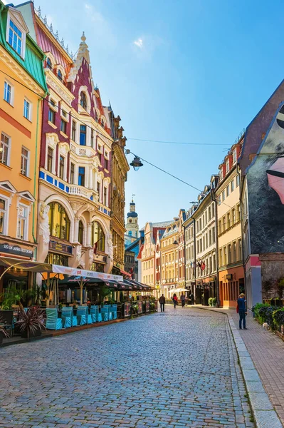 Rua com pessoas e pináculo da Câmara Municipal de Riga — Fotografia de Stock