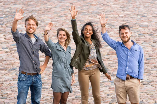 Group of young friends waving their hands — Stock Photo, Image