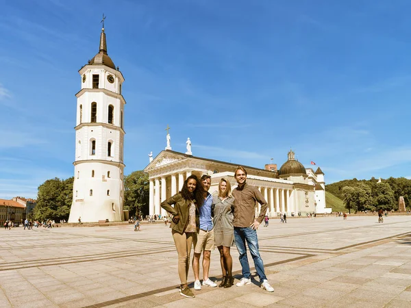 Smiling young multiracial friends on Cathedral square of Vilnius — Stock Photo, Image