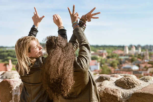 Två flickor visar kärlek tecken av fingrar och njuta av staden — Stockfoto