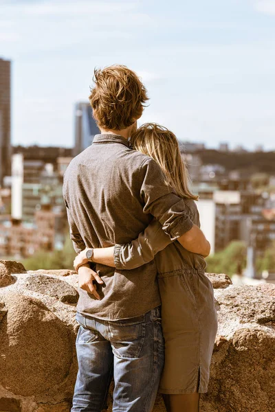 Mladý pár objímání a při pohledu na panorama města — Stock fotografie