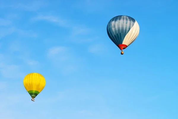 Globos de aire caliente de color azul y amarillo en el cielo — Foto de Stock