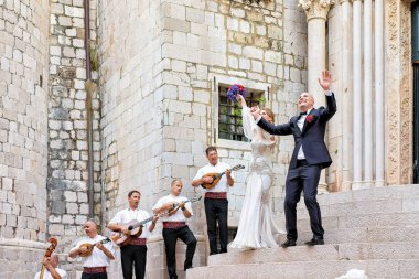 Gelin ve damat ve Dubrovnik'in church yakınındaki müzisyenler
