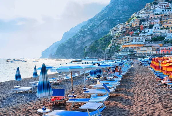 Pláž se slunečníky ve městě Positano a Tyrhénském moři — Stock fotografie