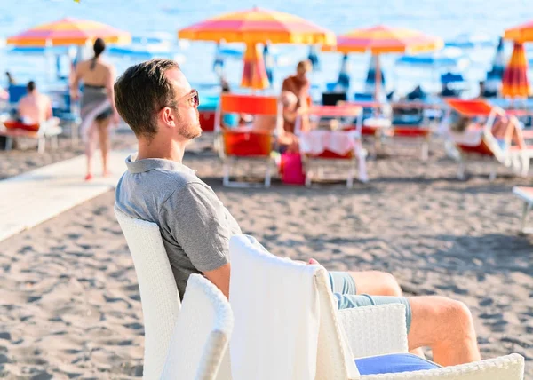 Mężczyzna na plaży z parasolami w mieście Positano — Zdjęcie stockowe